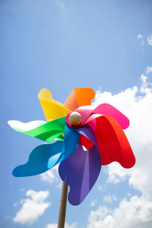 Photo shoot of some multicolored pinwheels thrown into the blue skyの写真素材