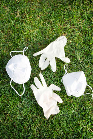 Photographic representation of a pair of disposable anti gloves thrown into the ground causing pollution.の写真素材