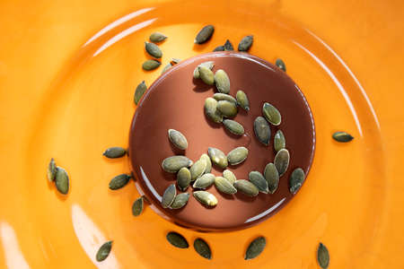 Photographic presentation of a vegan dessert, pudding with soy milk, cocoa and brown sugar and pumpkin seedsの写真素材