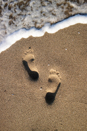 Photographic documentation footprints of people on gray sandの写真素材