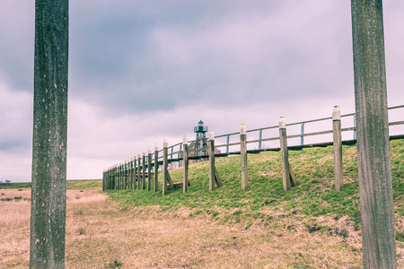 Old Port of the former Zuiderzee island; \"Schokland\" in the polder in the Netherlands. This world heritage of UNESCO shows a reconstruction of the breakwaters, piers, docks, lighthouse keepers house and light show. A residential mound amidst an agricultの写真素材