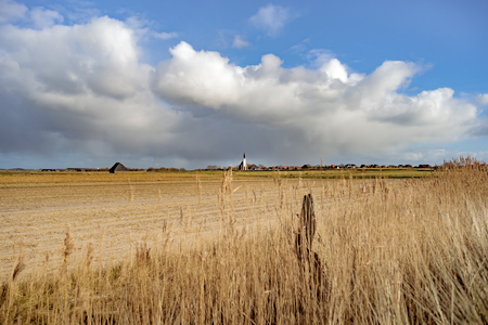Panoramic shot of old Dutch church. Farmland. Stormy cloudy sky. Texel. Den Hoorn. Wadden island. The Netherlandの写真素材