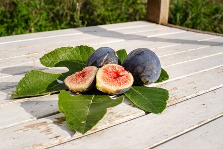 Fully Cut fresh figs on naturally weathered wood backgroundの写真素材