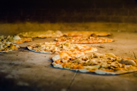 Tasty pizza inside traditional oven with the flameの写真素材