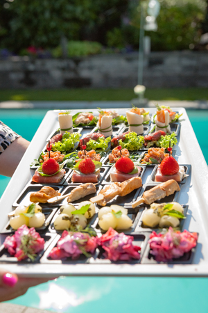 Small dishes on a plateau with a variety of fruits, vegetables, fish and meatの写真素材