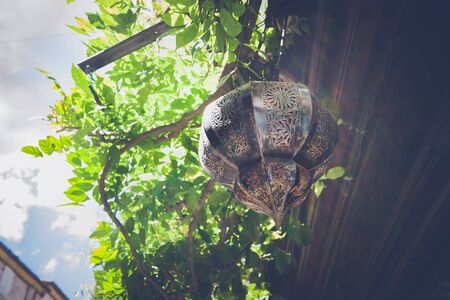 Sun flare on older antique lamp with arabic decorations, Hanging outdoor with sunflareの写真素材