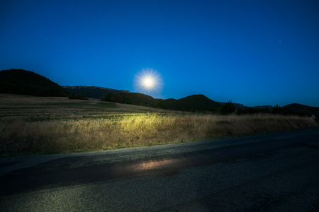 Clear summer evening with a pretty full moon above the fields in Franceの写真素材