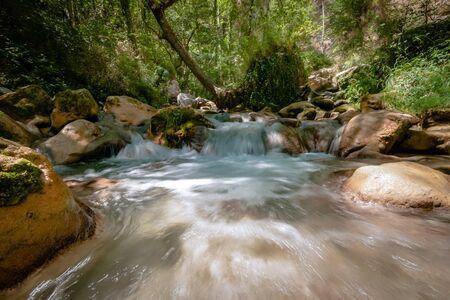 Photo from mountain river that runs usually in mountains, in narrow, deep valley with steep banks, rocky stream bed, and accumulated rock debris. Mountain rivers are characterized by high slope and flow velocity, insignificant depth, frequent rapids and wの写真素材