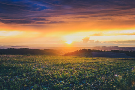 Atmospheric sunset with film-like strip of sunlight. Storm clouds and rain clouds give a nice evening over the RhÃ´ne Valley in Franceの写真素材