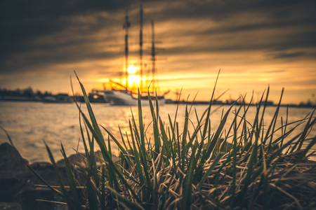silhouette of historic sailboats on the rivers of the Netherlands. The evening falls in and in an...