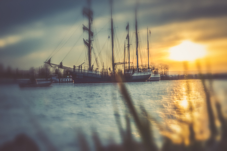 silhouette of historic sailboats on the rivers of the Netherlands. The evening falls in and in an...
