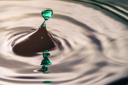 Drop or water in different colors and shapes, created a beautiful shape after hitting a water surface. Captured through high speed photographyの写真素材