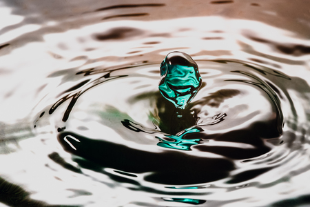Drop or water in different colors and shapes, created a beautiful shape after hitting a water surface. Captured through high speed photographyの写真素材