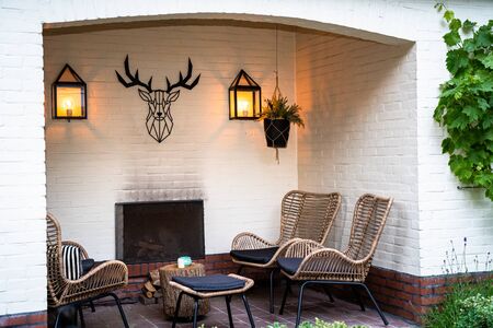 outdoor lounge set in a green garden in the alcove of a white painted buildingの写真素材