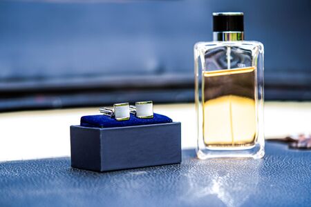 Silver cufflinks in a luxurious black box with velvet blue trim and a natural background of firewoodの写真素材