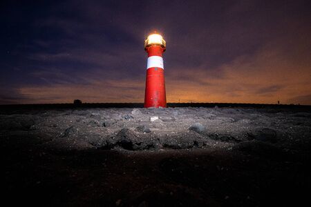 Small vintage lighthouse along the sea dike at Westkapelle in Zeeland, the Netherlandsの写真素材