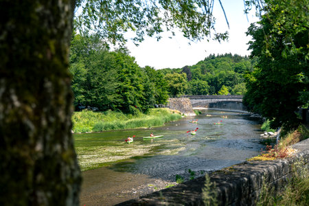 Canoe and kayak on the river Ourthe passing the village of Durbuy in the Belgian Ardennesの写真素材