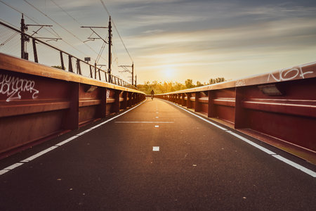 Wonderful sunrise at river bridge with train track and bike path along the river 'de IJssel' Near the capital Zwolle, Netherlandsの写真素材