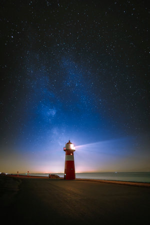Lighthouse and the Milky Way above the North Sea on the sea dike in Zeeland near Westkapelle, the...