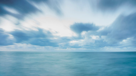 Rocks with green seaweed in the light of the setting sun and waves. Long exposure photography on the Dutch coast, Zeeland, Netherlandsの写真素材