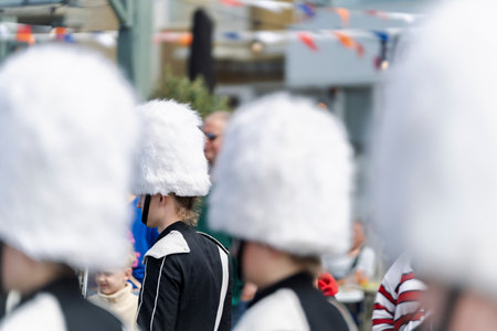 Marching band members, with distinctive white fluffy hats and uniforms, move in formation during an...