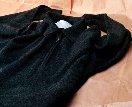 a black sweater laying  on brown wrapping paperの写真素材