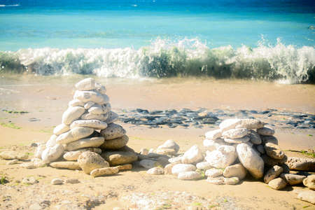 Pile of stone on the beach on the lighthouse Phare des Baleines on the isle of Ile de RÃ© in...