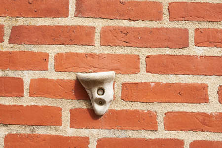 Closeup of a climbing grip on a red concrete wallの写真素材