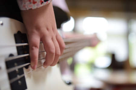 A girl playing a white electric guitarの写真素材