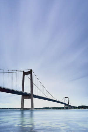 a long bridge with blue water and blue skyの写真素材