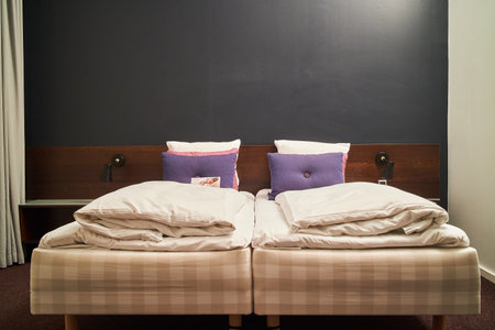 two small beds in a cozy hotel roomの写真素材