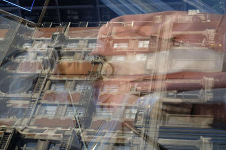 Mannequinn in a shop window with reflection of the surrounding buildings. London, UK.