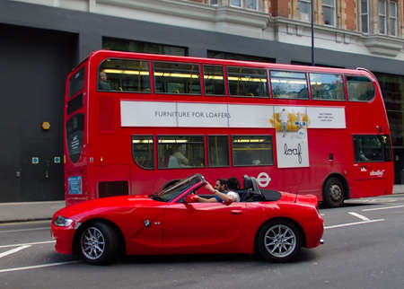 Red bus and red car in London, United Kingdom.の写真素材