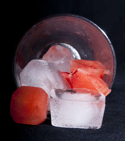 Closeup of Red and clear ice in a glassの写真素材