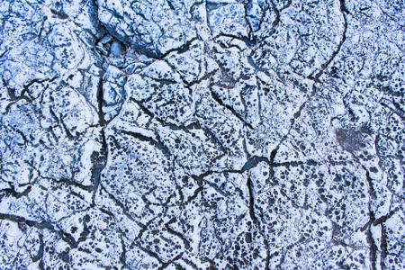 huge rock pattern on coast with lines formed by waterの写真素材