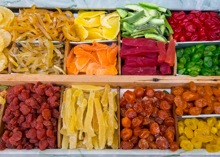 dry fruit mix on a pile on a food market, coloful dry fruits, dried fruits, different types of dry fruits, Assortment of dried fruits closeup background in square cells. Decorative pattern of dry exotic fruit. Top view.の写真素材