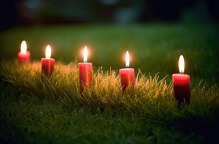 Burning candles on green grass background. Shallow depth of fieldの素材
