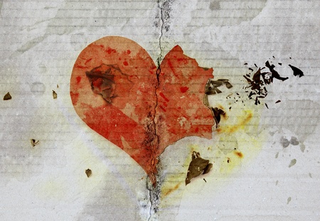 burned and tear heart on paper background の写真素材