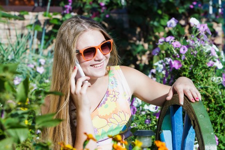 Portrait of a child girl with a phone in sunglassesの写真素材
