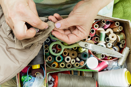 Working hands of a seamstress with a needle, scissors thread.の写真素材
