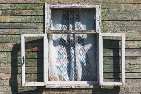 Old wall of wooden house with open window