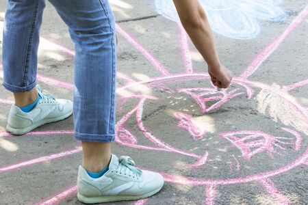 Girl draws with crayons on the road.の写真素材