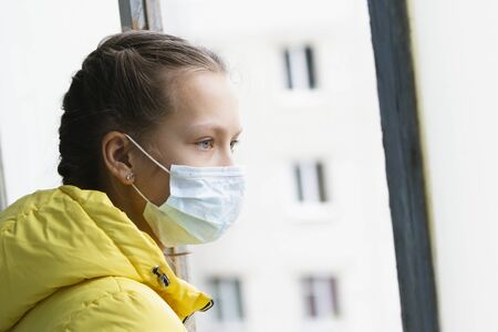 Quarantined girl in medical mask at home