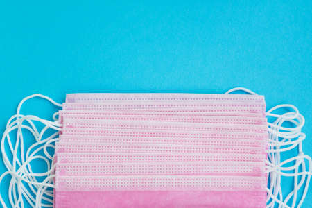 Surgical medical masks on a blue background with space.