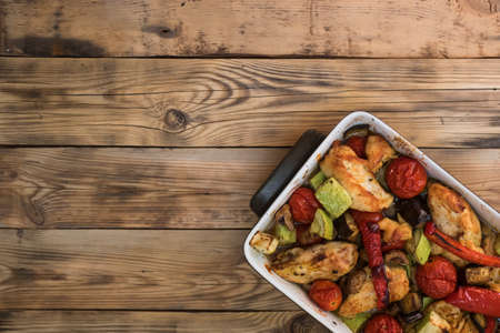 Stewed chicken with vegetables on a wooden background.の写真素材