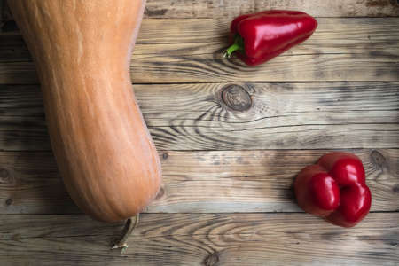 Pumpkin and sweet red pepper on a wooden background.の写真素材