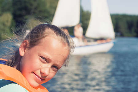 A girl in a life jacket on a lakeの写真素材