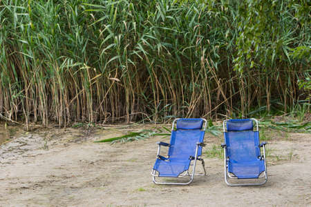 Folding chairs on the shoreの写真素材