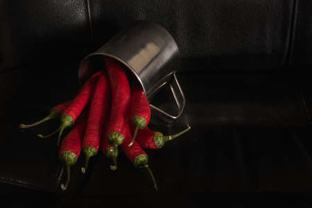 Red hot chili pepper in an iron mug on a dark backgroundの写真素材