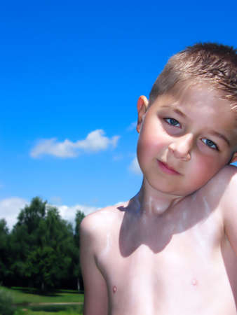 A boy outdoors who is creamed with a solar protection cream.の写真素材